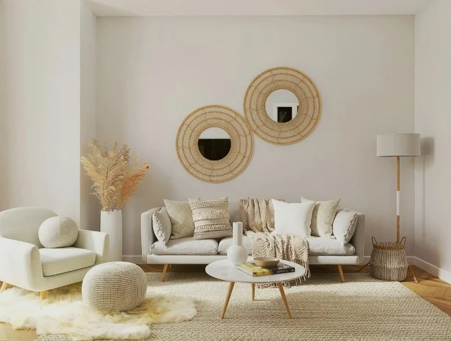 Living room in white and natural tones with a linen sofa, paired rattan round mirrors, a pampas grass floor arrangement and a jute rug