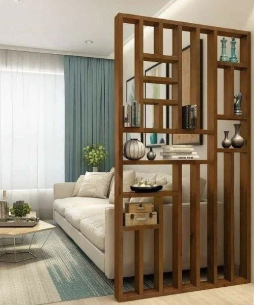 Living room with a freestanding timber grid partition acting as a room divider, with display shelving on its face and a white sofa behind