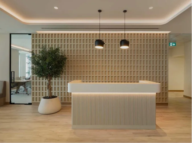 Office reception with a backlit fluted desk and a timber lattice feature wall